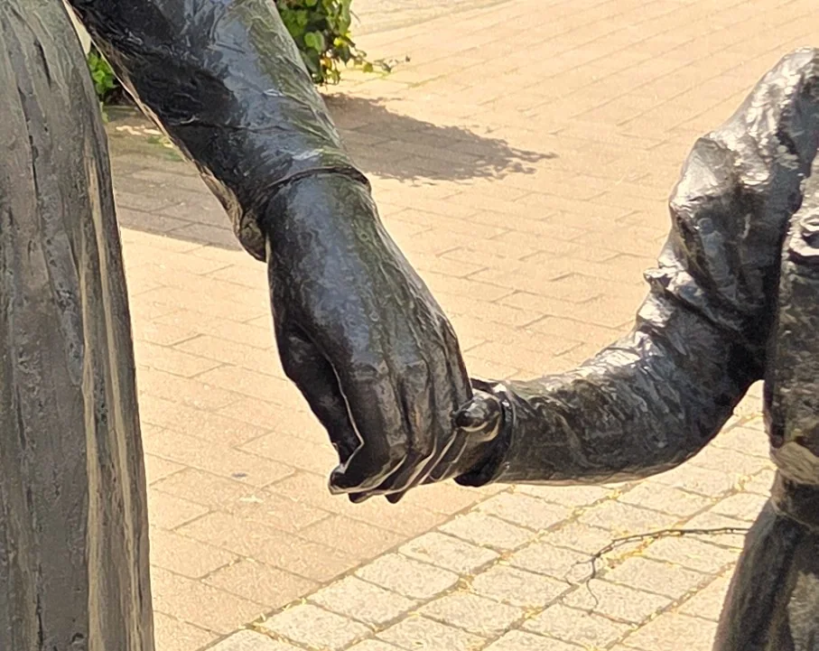 Zwei sich haltende Hände der Bronzefiguren in der Groß-Gerauer Innenstadt