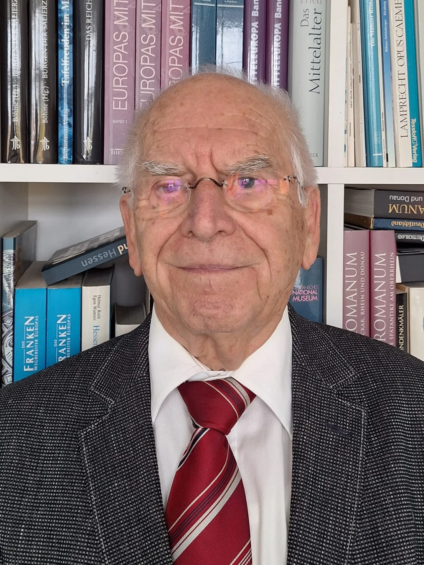 Porträtfoto von Klaus Meinke vor einem Bücherregal mit historischen Fachbüchern